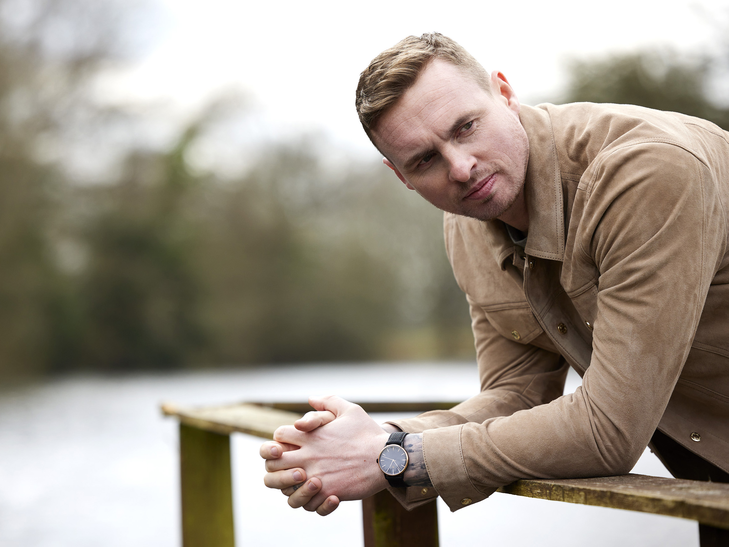 David Stockdale leaning on a wooden barrier by a lake