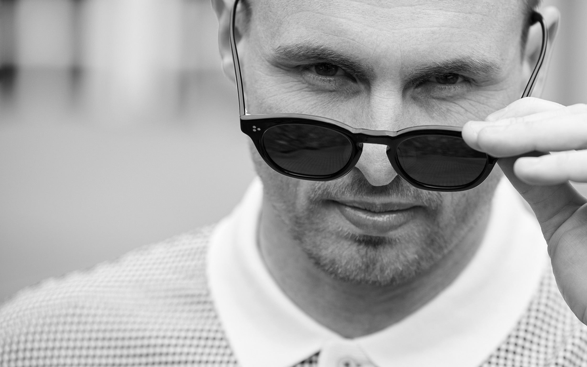 David Stockdale looking at the camera while holding a pair of sunglasses on the tip of his nose