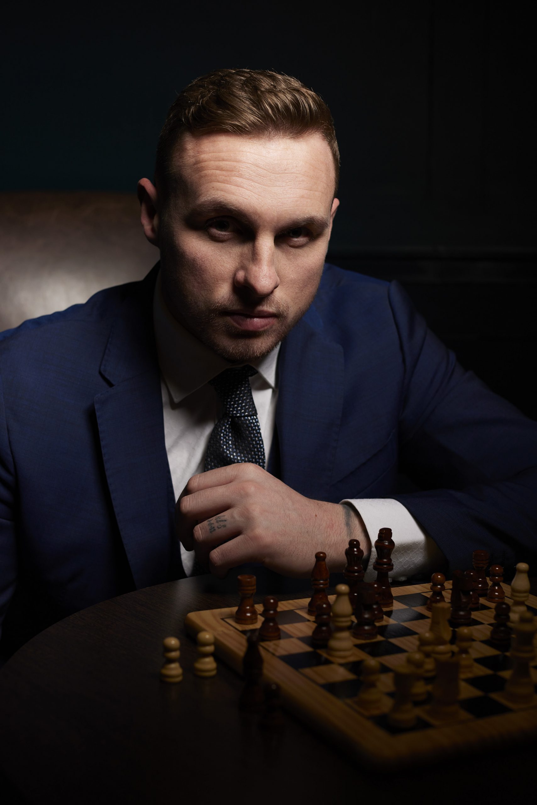 David Stockdale wearing a blue suit and playing chess